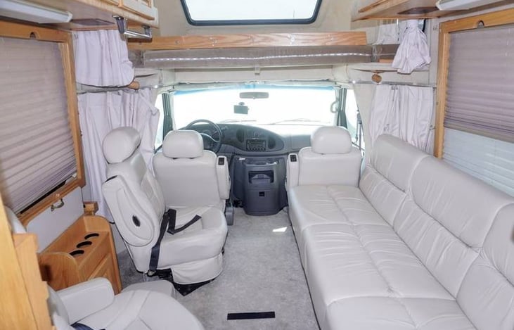 white comfortable leather seats and leather couch and upper berth to sleep one adult or two kids