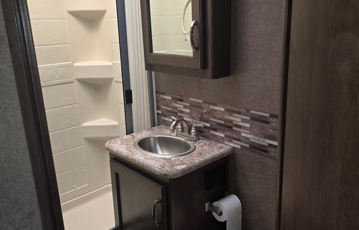 Bathroom with standup shower, sink, and commode