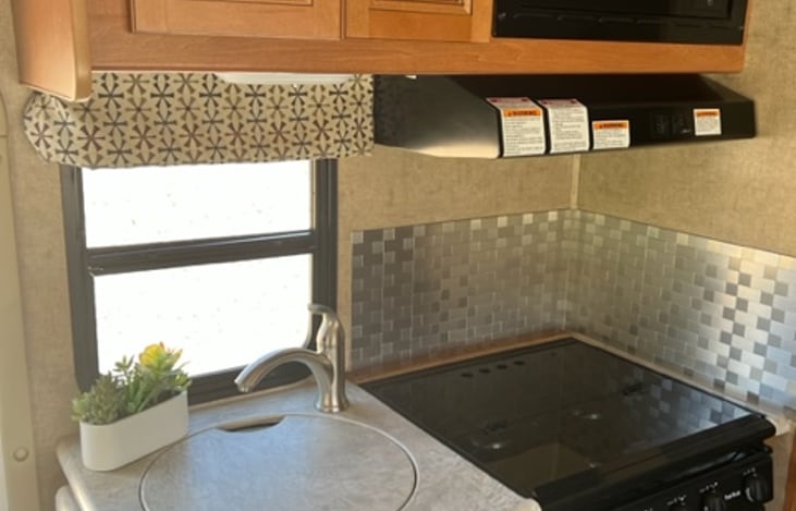 Kitchen! 3 burner stove, microwave, and sink.