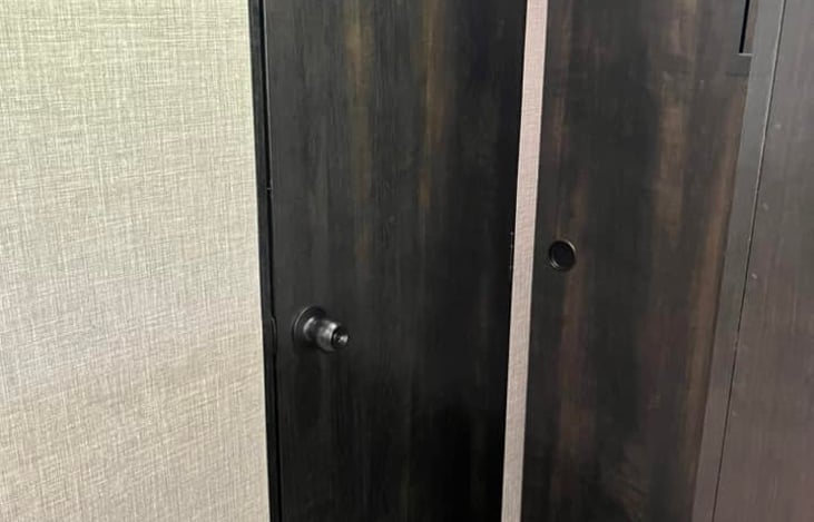 Closed bathroom door to the left, closed bunk house door to the right.