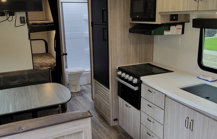 Full kitchen with microwave, 3 burner range, and oven.