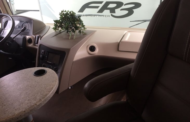 Adjustable table with cup holder on each end that allows for passenger and driver drinks.