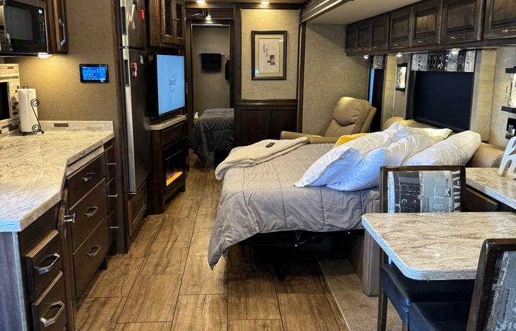 couch converted to an inflatable queen bed, electric fireplace below TV