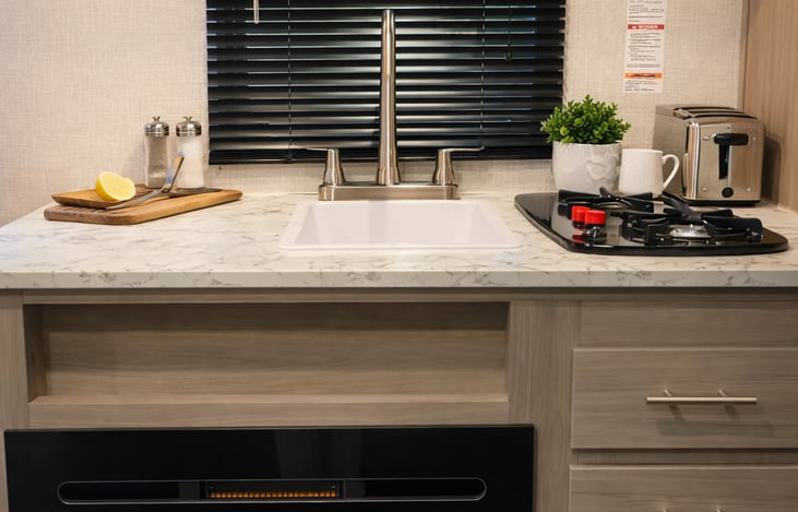 Fully stocked kitchen with 2 burner stove, microwave, refrigerator, toaster, and coffee maker