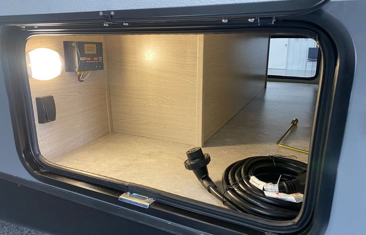 Close-up of pass thru storage with panel doors on both sides shown open