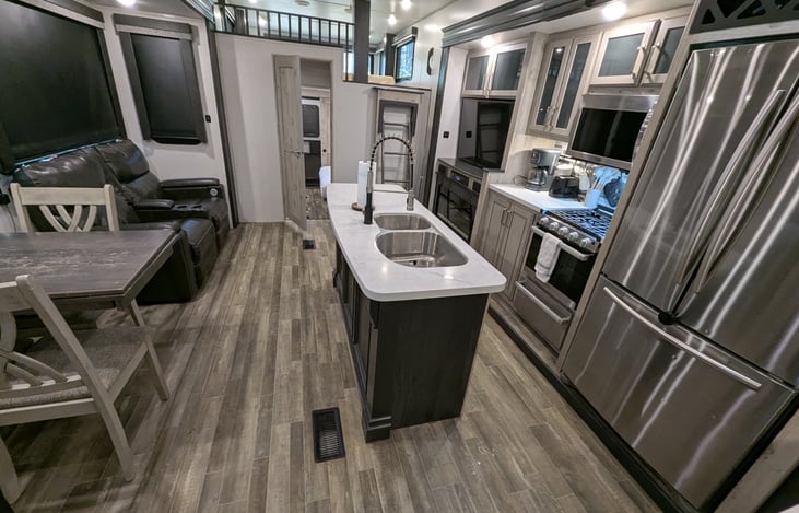 Chef’s dream galley! Features a massive 18 cu. ft. fridge, residential microwave, and 3-burner stove. Enjoy the solid-surface islands, deep sink, and pantry—perfect for feeding the whole crew.