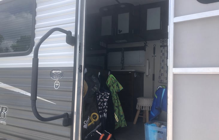 View from the outside in. Set up with shoe basket and hooks perfect to hang jackets, hats, backpacks+. Compete with automatic safety light. As well as fire extinguisher for easy grab in or outside.
