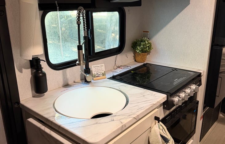 Clean kitchen with basic cooking supplies and dish soap dispenser