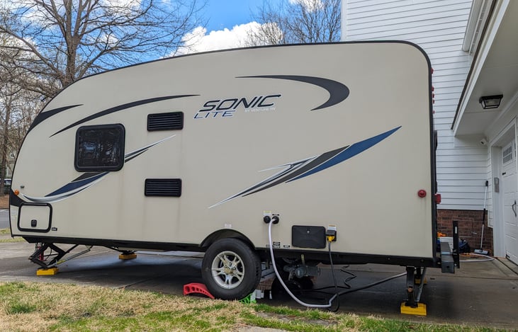 Camper also has a pass-through storage compartment at the front with all the tools you need for full hook-ups. We also include a spare tire mounted to the bumper (not shown).