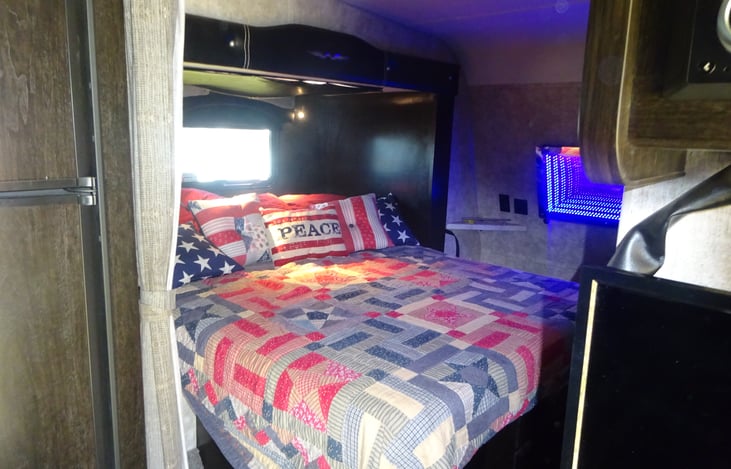 Queen size bed in slide out with star gazing skylight above.