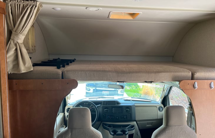 over the cab bunk that sleeps two, roughly queen size bed. Has a light blocking curtain for longer sleep-ins.