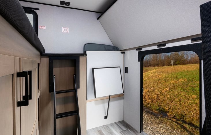 JayBird, Bunkhouse view with door open to outside and bunks folded up for extra storage options.