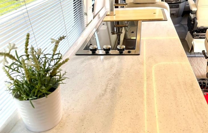 Extra-length counter area for prepping food. With 3 burner stove and sink.