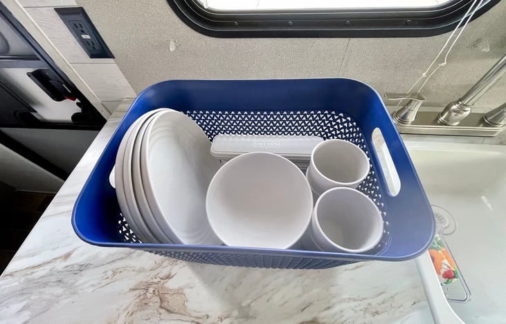 4 set of table wear provided as well as cook wear such as two pots, a strainer, and cooking utensils.