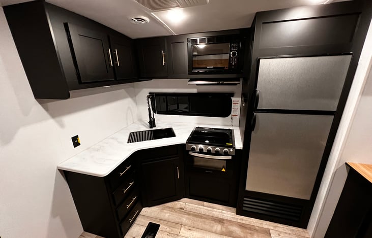 Deep sink, Oven, Microwave and Large refrigerator and freezer. With plenty of cabinet space above and underneath.