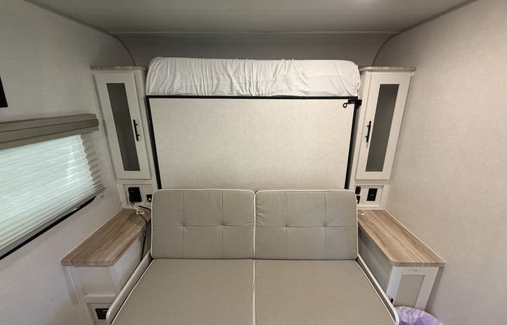 Murphy bed couch folded up with his and hers closets. USB and outlets on both sides of the bed. Extra storage underneath the couch.