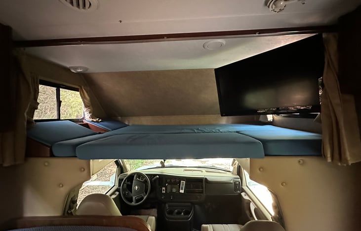 Over cab queen size bed. This bed will have a two inch memory foam mattress topper as well as a waterproof mattress cover and very comfortable linens included in the rental fee. Tv mounted on top.