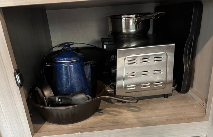 Kitchen cabinet with cookware and toaster oven