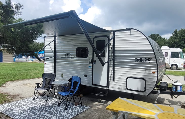 Typical layout with 10 foot power awning extended, 2 full sized camping chairs over a 6 x 9 reversible mat; 2 smaller chairs for kids also supplied. All accessories included