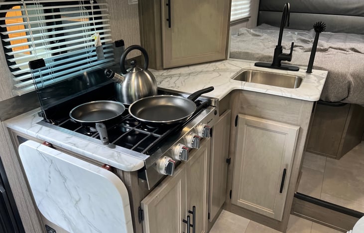 Kitchinette has a sink and a stove with 3 burners.