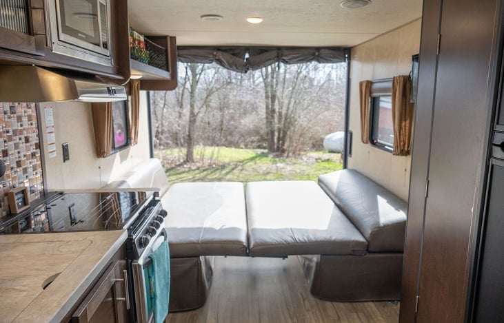 Walking into camper looking to left - view of table in down position converted into bed.  Ramp door open