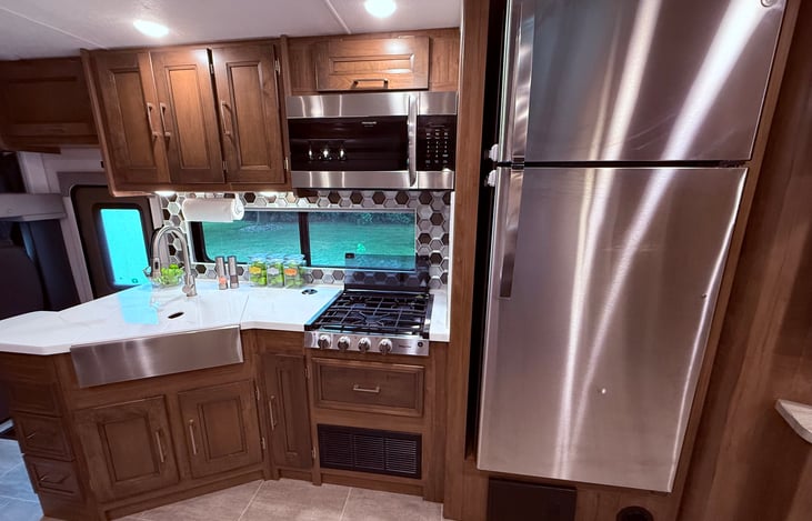 Kitchen complete with stove top, residential size refrigerator and convection microwave/oven.
