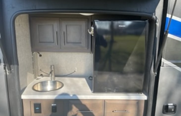 Outdoor kitchen with sink and fridge.  Use of Blackstone grill can be added.
