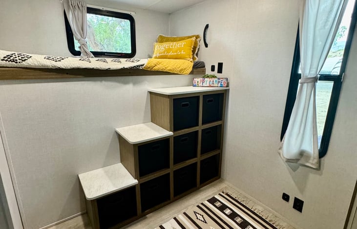Stairs to the top bunk offer plenty of storage space in the cubicles.