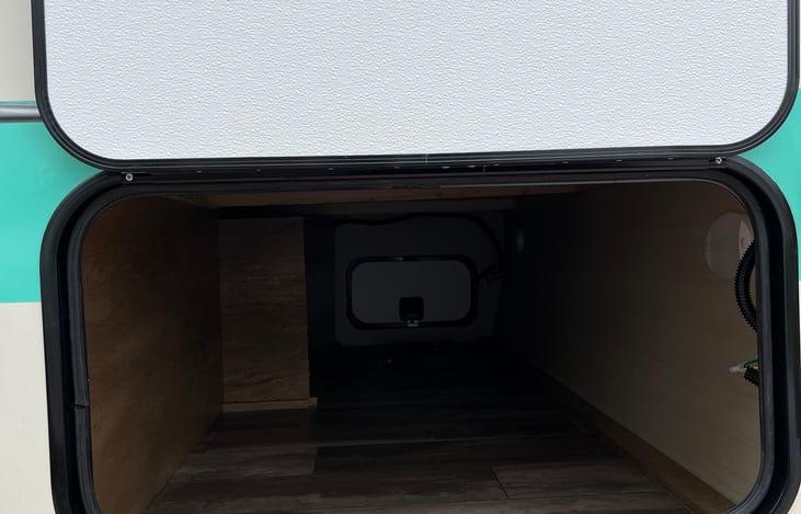 Spacious storage for suitcases and other items. Doors opens and allows access on both sides of the camper.