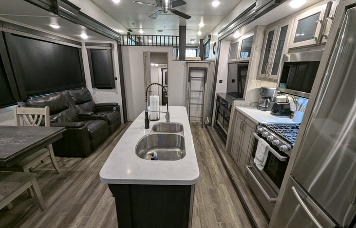 Chef’s dream galley! Features a massive 18 cu. ft. fridge, residential microwave, and 3-burner stove. Enjoy the solid-surface islands, deep sink, and pantry—perfect for feeding the whole crew.
