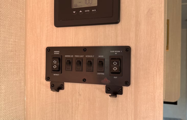 Battery screen, awning, led, slide and interior light control. To the left at entry.