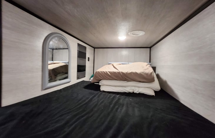 The loft sleeping quarter will fit 1 adult or 1-2 children. Has a mirror, and storage compartments.