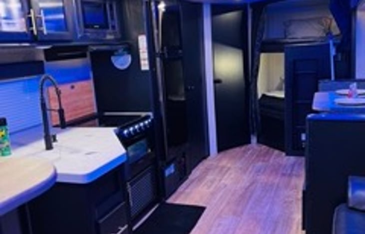 Kitchen with large refrigerator, stove/oven, microwave, and ample storage