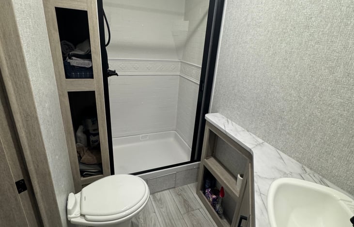 Bathroom- toilet, sink, vanity above sink, and ample counter space.