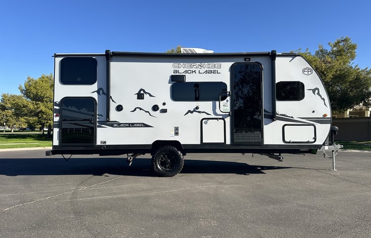 Entry-side exterior profile with awning, door, and outdoor storage visible.