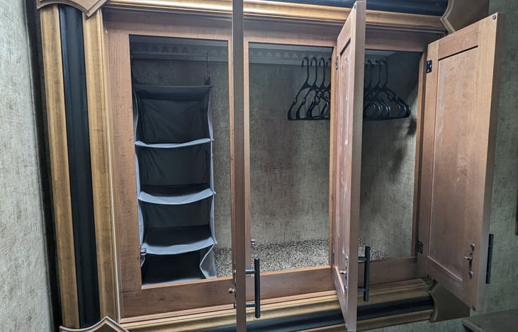 Full-size slide-out closet, includes hangars and storage cubbies.