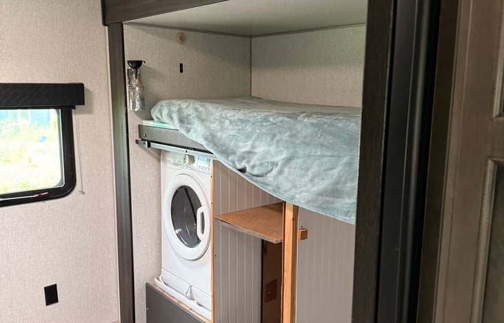 Bunk room with single bunk over W/D and storage area