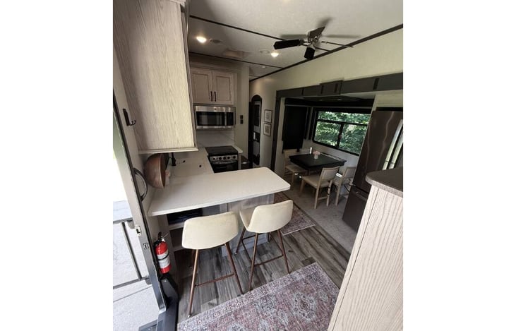 Stunning kitchen with full-size fridge, dining table with four chairs, two bar stools, microwave, gas top stove, and oven!