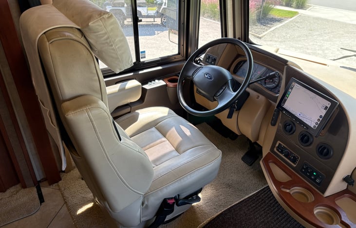 captains chair with a neck support, apple carplay, android auto, google maps, a loud stereo system with speakers throughout the coach and a subwoofer