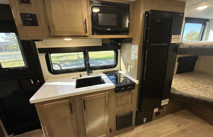 Kitchen counter, microwave, stove, and refrigerator area.