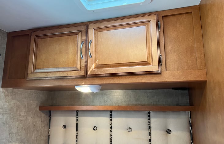 Storage over the bed is really deep. It's a great place to keep clothes and personal items, as well as blankets. There are outlets over the bed and a little shelf so it makes charging phones easy.