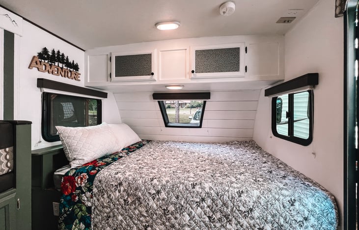 A comfy queen bed surrounded by 3 windows and a hanging tv for those rainy glamping days.