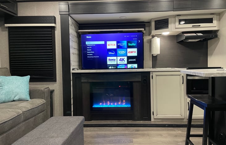 Smart Roku TV (rises from cabinet below), electric fireplace in lounge area