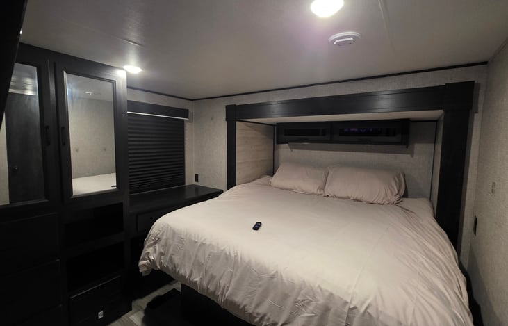 King Size Bed near the back of the camper with a large closet
