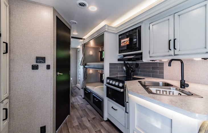 Spacious kitchen leading to hallway with bunkhouse. View of MID Cab of RV.