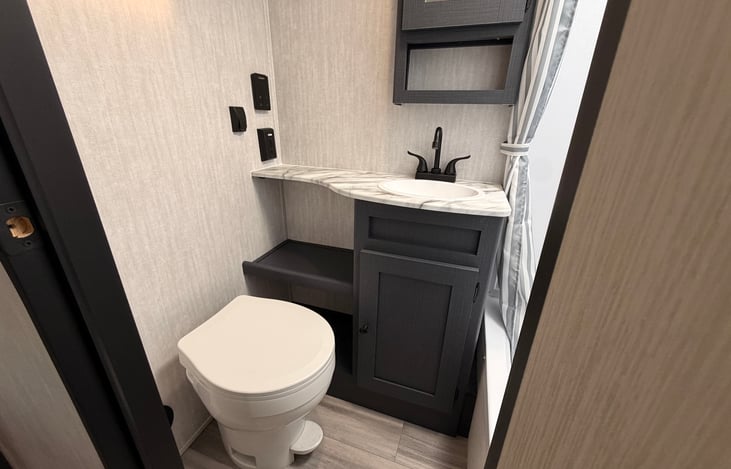 Roomy toilet area with Insta Hot water system on wall.