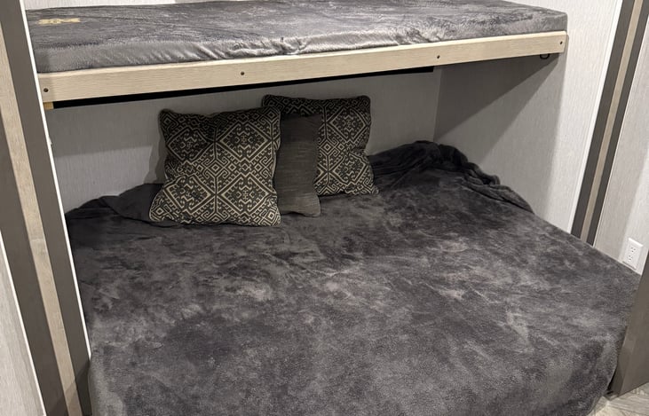 Back bedroom. To the right with couch made into bed and bunk pulled down.