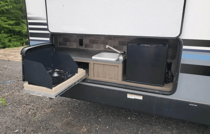 Outdoor kitchen (2 burner range, sink, counter space and mini fridge).