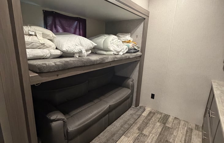 Twin bunk on top and sofa that opens to a queen bed below.