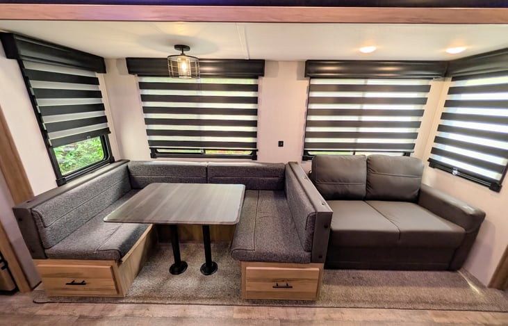 Spacious dinette and cozy couch surrounded by windows both convert to comfy beds.